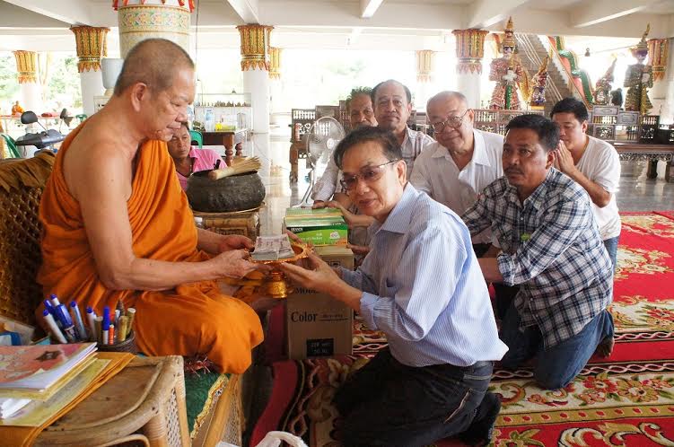 Songchai haciendo una donación a un monje